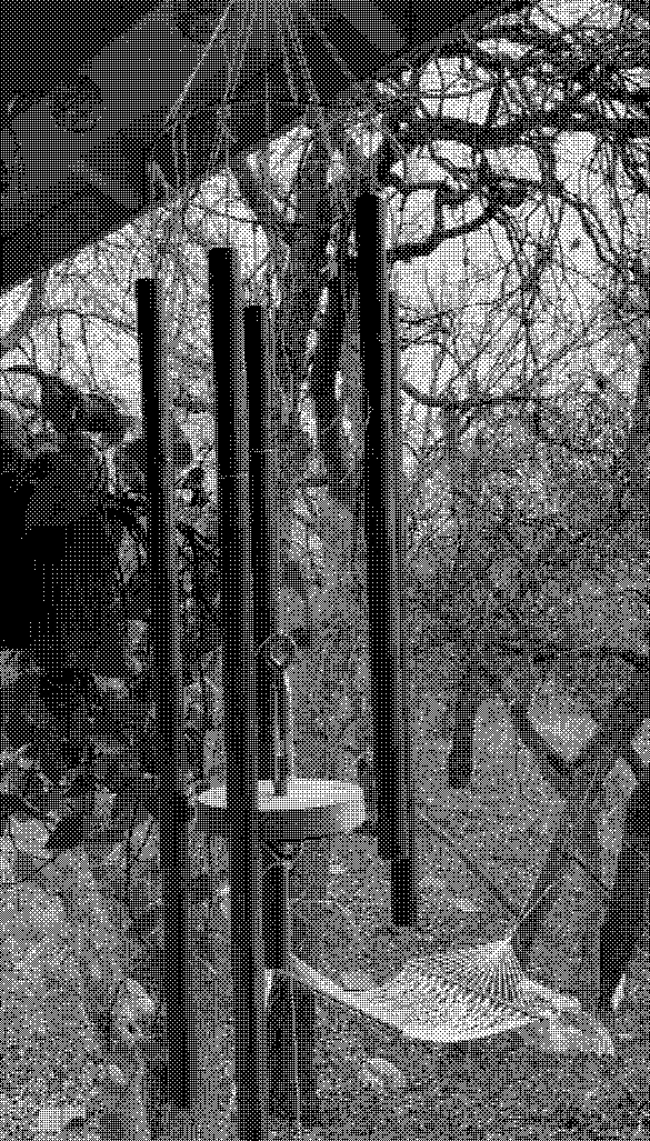 A photograph of the chimes, hanging on Taylor’s porch. There are five chimes of varying lengths, hung from a metal hoop. In the center of the chimes is a wooden striker. In the background, there’s a wooded area, with a hammock hung between two trees.